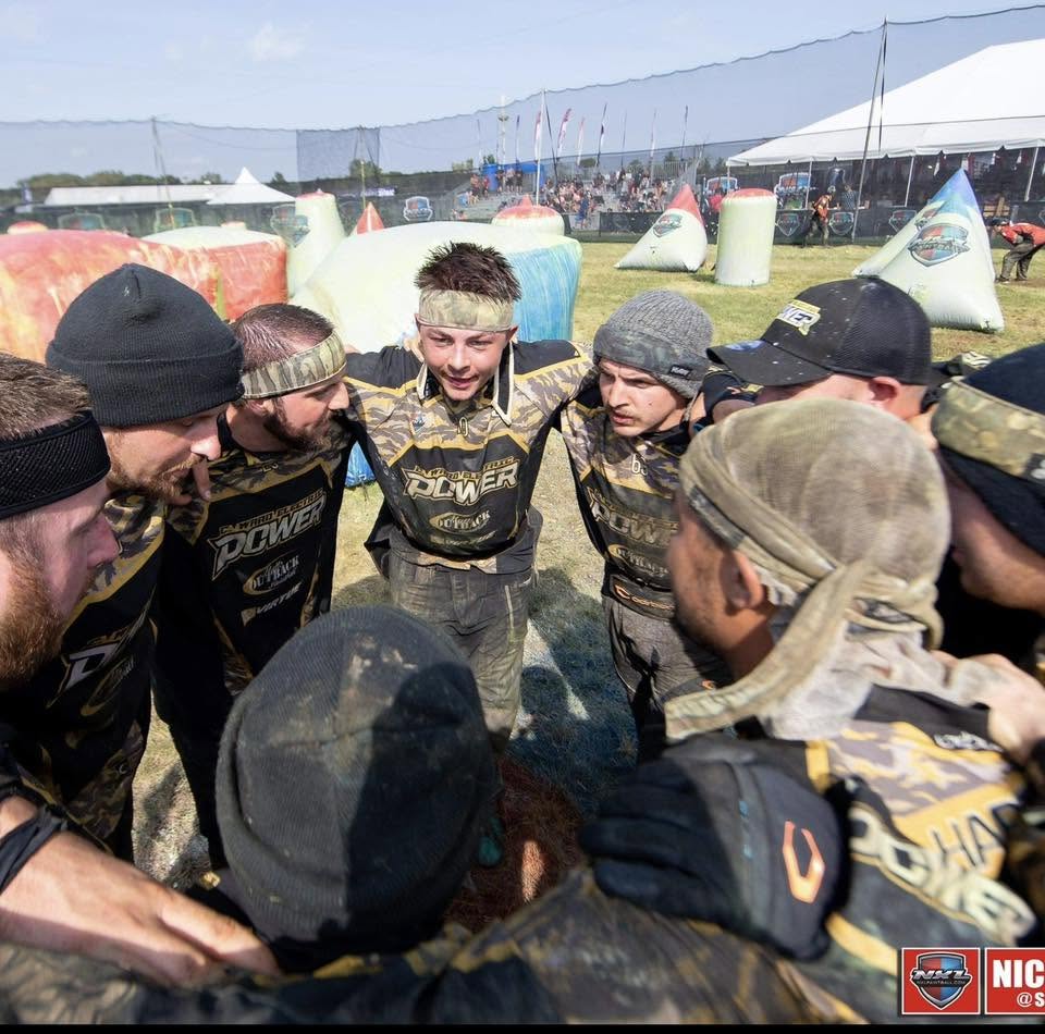 Team Power in a pre-point huddle on the outdoor speedball field